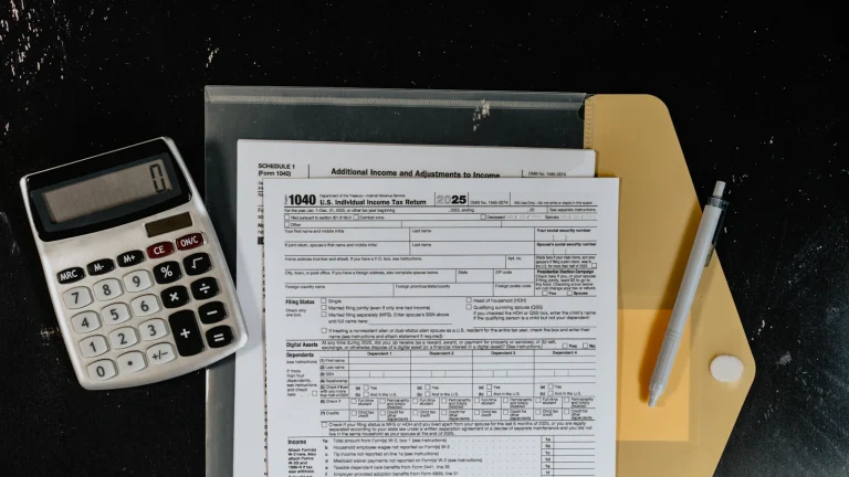 Calculator and property tax forms on a dark desk, for working out a tax proration at closing